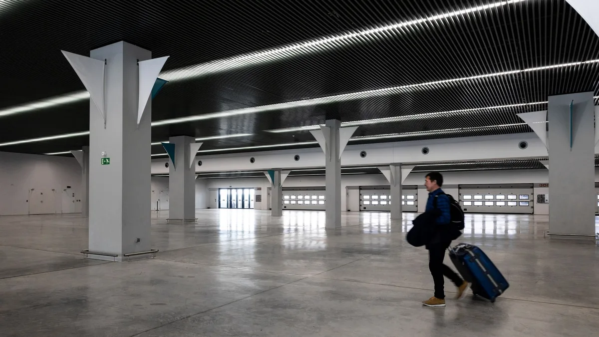Traveller with a rolling suitcase walking through a modern airport terminal, illustrating expat tax planning abroad