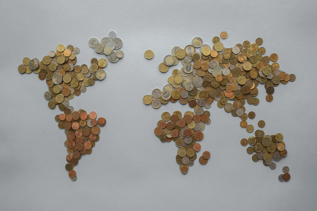 World map made of assorted coins, representing which countries pay the highest salaries after tax