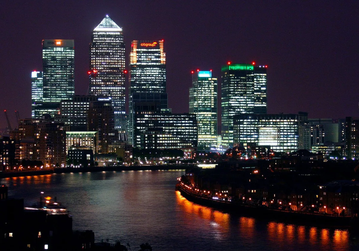 Canary Wharf in London lit up at night, illustrating UK tax on a GBP 100,000 salary