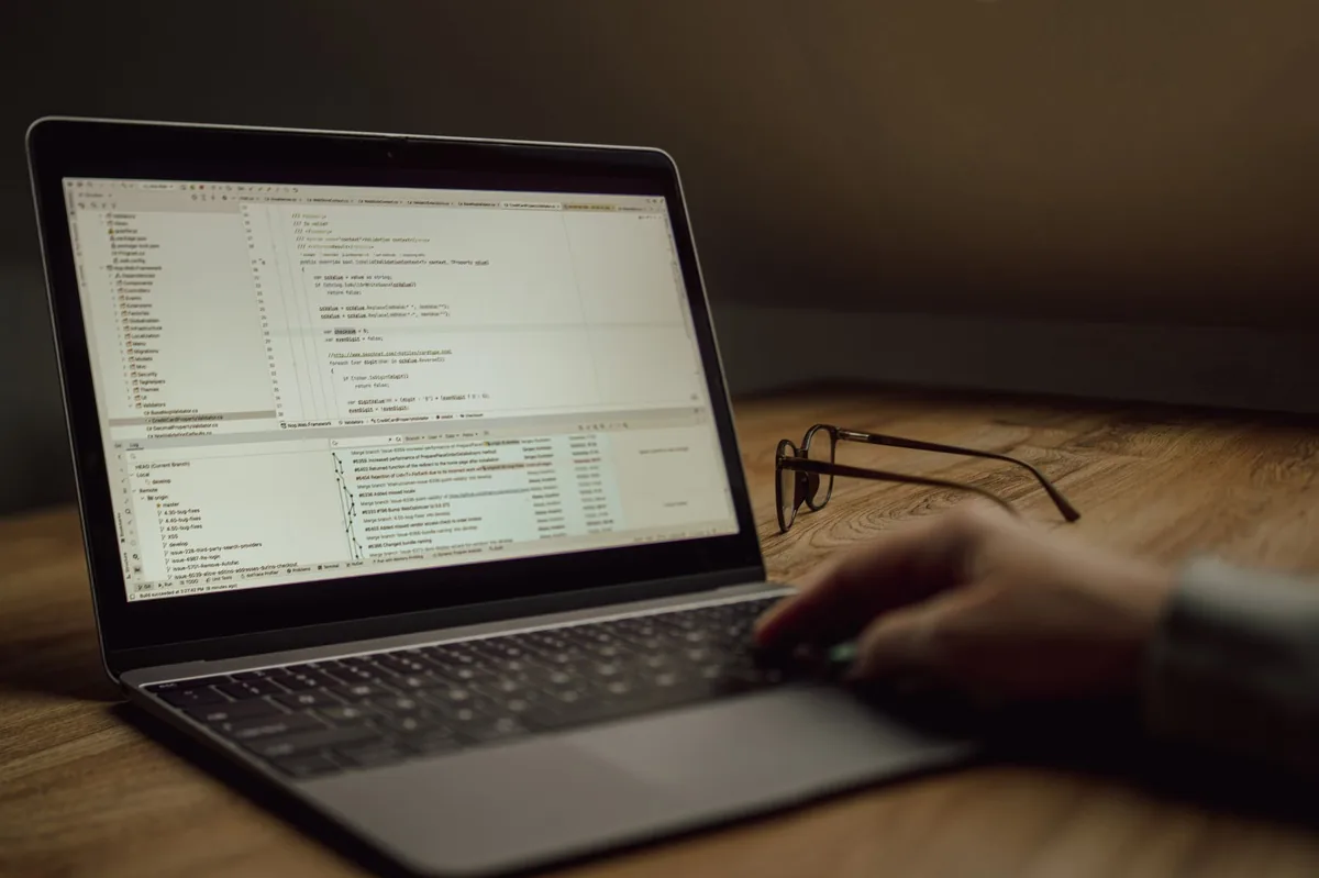 Software developer writing code on a laptop at a desk, representing global software engineer salary after tax