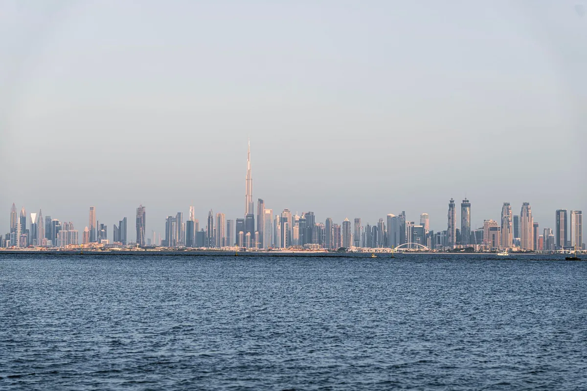 Dubai skyline with the Burj Khalifa seen across the water, representing the UAE side of a UAE vs UK tax comparison